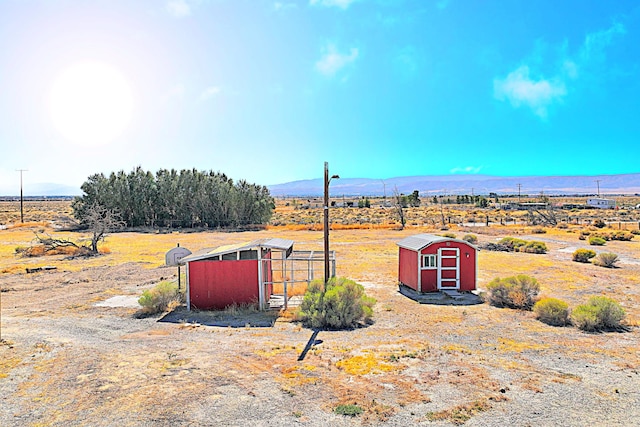 view of yard featuring a mountain view, a rural view, and a storage unit