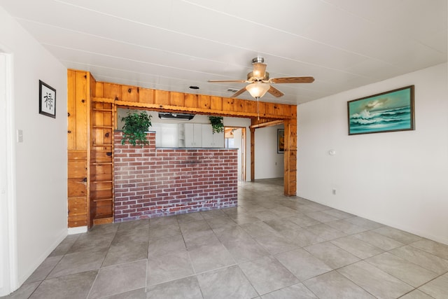 empty room featuring wooden walls and ceiling fan