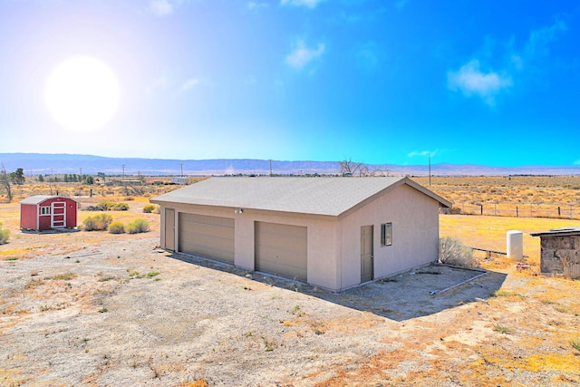 garage with a mountain view and a rural view