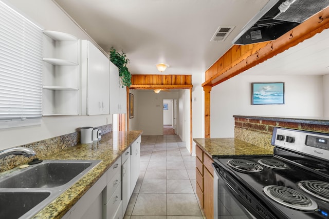 kitchen featuring electric range, sink, light tile patterned floors, stone countertops, and white cabinets