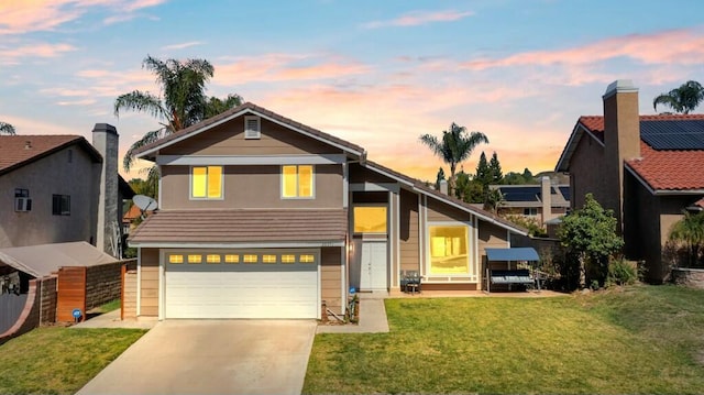 traditional-style house featuring a front yard, an attached garage, and driveway