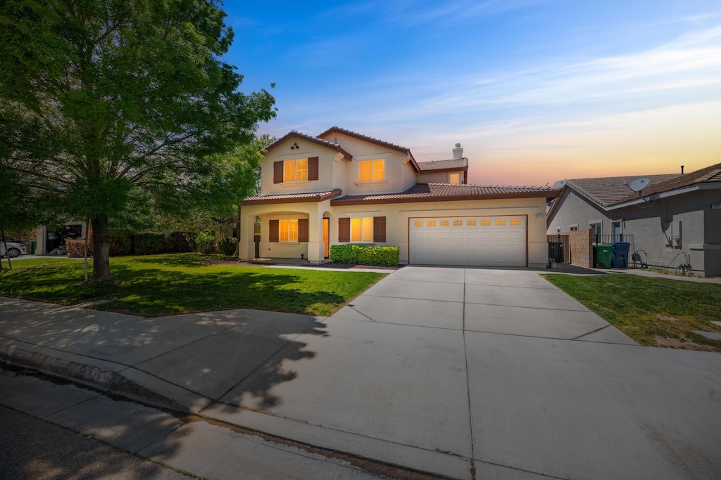43651 Sawgrass Ln, Lancaster, CA 93536 - traditional-style house featuring a tile roof, driveway, a yard, a garage, and stucco siding