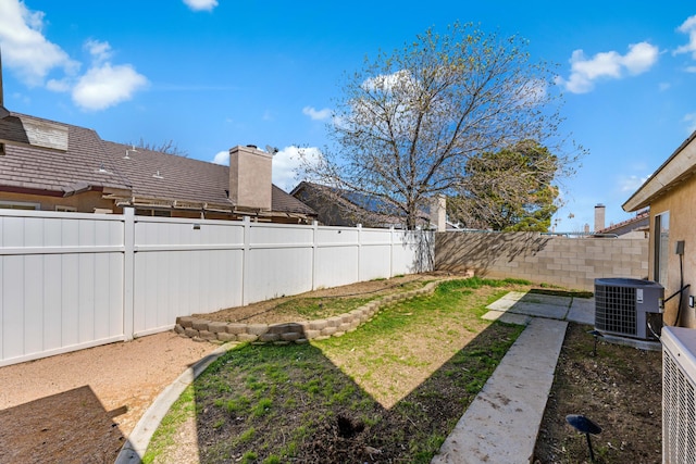 view of yard featuring central AC and a fenced backyard