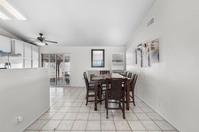 dining room featuring ceiling fan, visible vents, lofted ceiling, and light tile patterned flooring