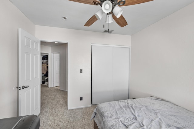 carpeted bedroom with visible vents, a closet, and ceiling fan