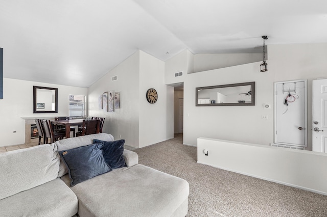 carpeted living area with lofted ceiling and visible vents