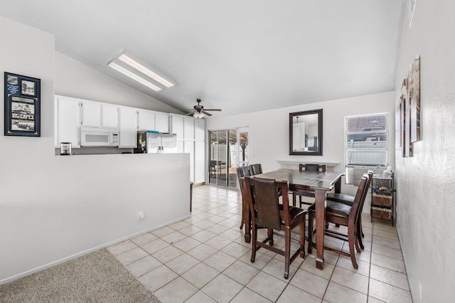 dining space featuring light tile patterned floors, ceiling fan, and vaulted ceiling