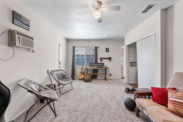 interior space with visible vents, a textured ceiling, an AC wall unit, and ceiling fan