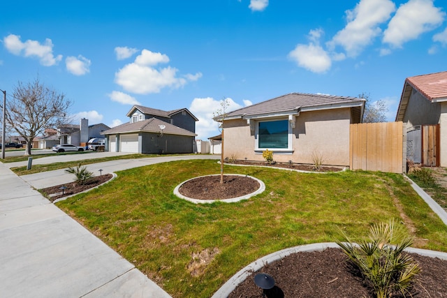 view of front of home featuring a front yard, fence, driveway, and stucco siding