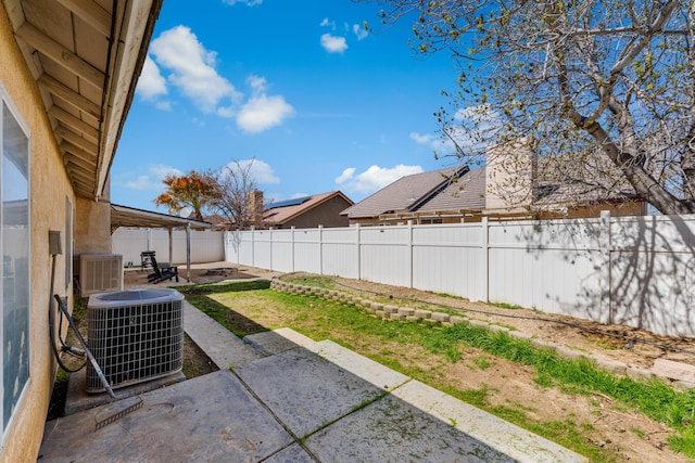 view of yard with a patio area, a fenced backyard, and central AC