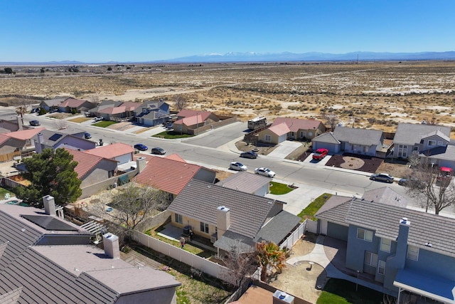 birds eye view of property with view of desert, a mountain view, and a residential view