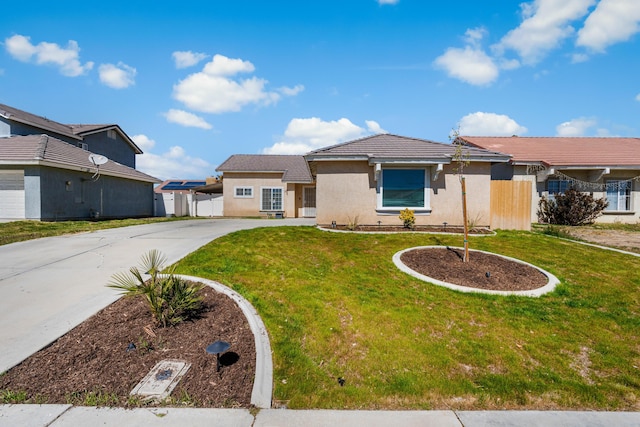 single story home with stucco siding, driveway, a front yard, and fence