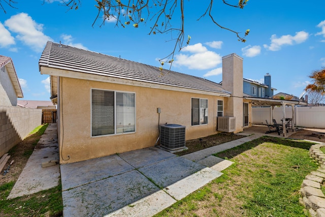 back of property with stucco siding, a patio, central AC unit, and a fenced backyard