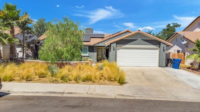 view of front of property with a garage and solar panels