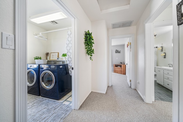 washroom with sink, light carpet, and washer and clothes dryer