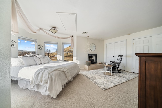 bedroom with carpet floors and a fireplace