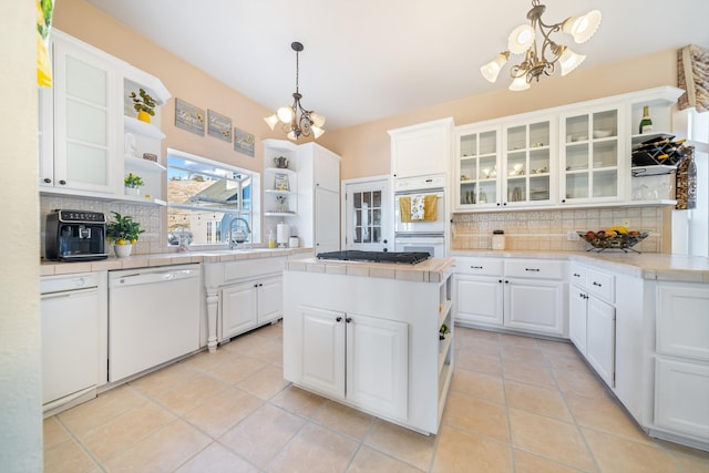 kitchen with an inviting chandelier, white cabinets, white appliances, and decorative light fixtures