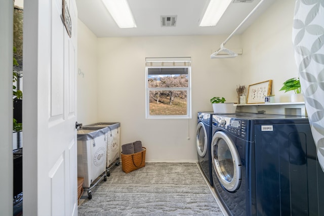 clothes washing area featuring washing machine and clothes dryer and light carpet