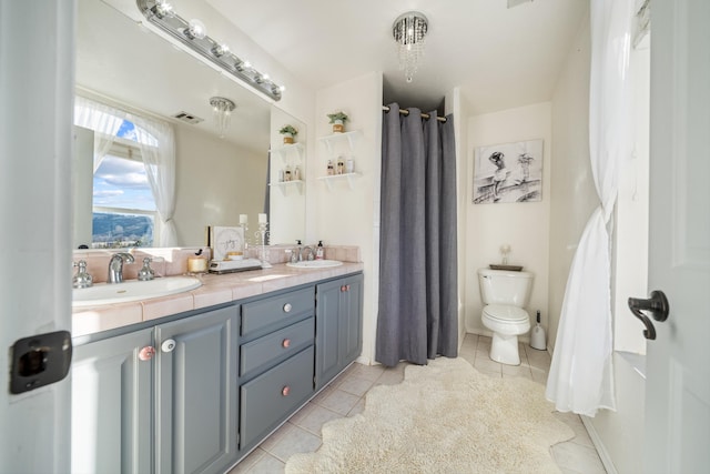 bathroom featuring vanity, tile patterned floors, and toilet