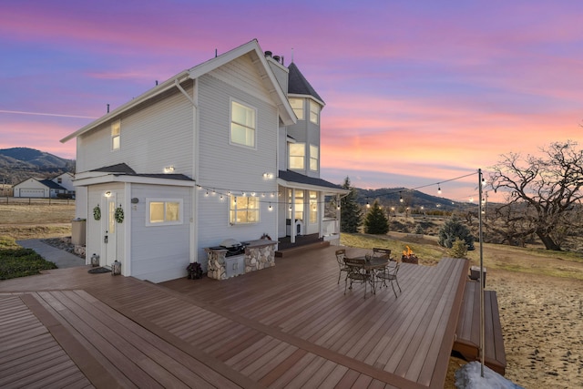 back house at dusk featuring a deck with mountain view