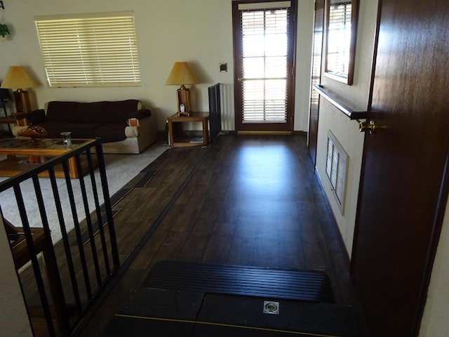 entryway with stairway, visible vents, and dark wood-type flooring