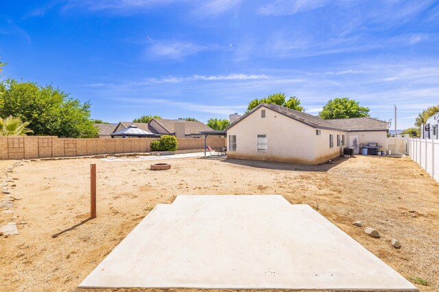 view of yard with a fenced backyard, cooling unit, a patio area, and an outdoor fire pit