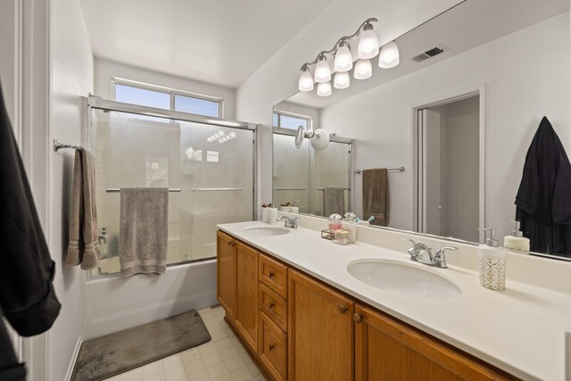 full bathroom featuring a sink, combined bath / shower with glass door, double vanity, and visible vents