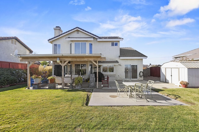 back of house with a lawn, a storage unit, and a patio