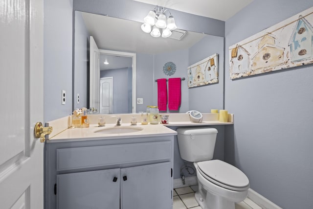 bathroom with tile patterned flooring, vanity, toilet, and an inviting chandelier