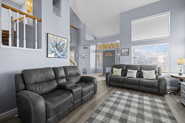 living room with high vaulted ceiling and hardwood / wood-style flooring