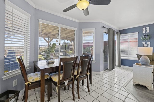 tiled dining space with ceiling fan and crown molding