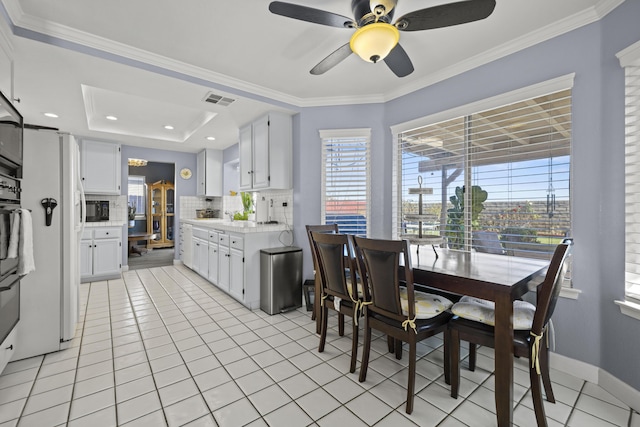 kitchen featuring backsplash, black appliances, a raised ceiling, ceiling fan, and white cabinetry