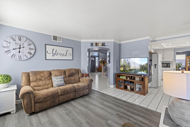 living room featuring light tile patterned flooring and ornamental molding