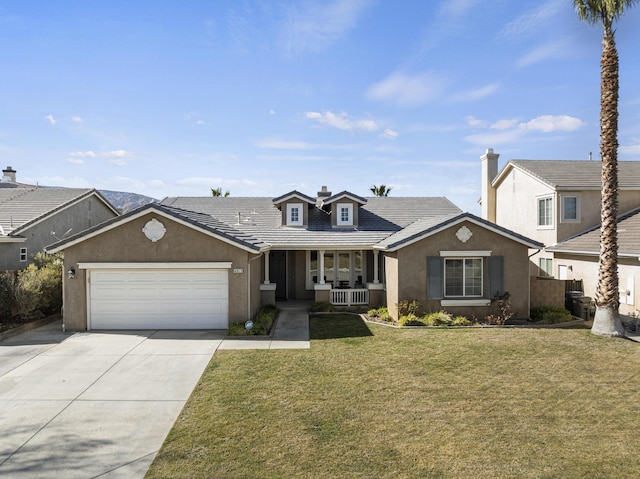 view of front of home with a garage, a front lawn, and covered porch