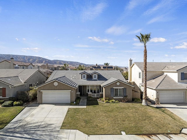 view of front of home featuring a garage, a mountain view, and a front yard