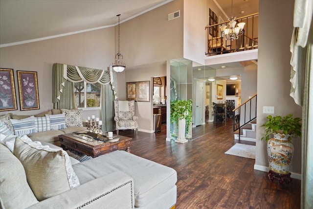 living room featuring dark wood-type flooring, high vaulted ceiling, ornamental molding, and an inviting chandelier