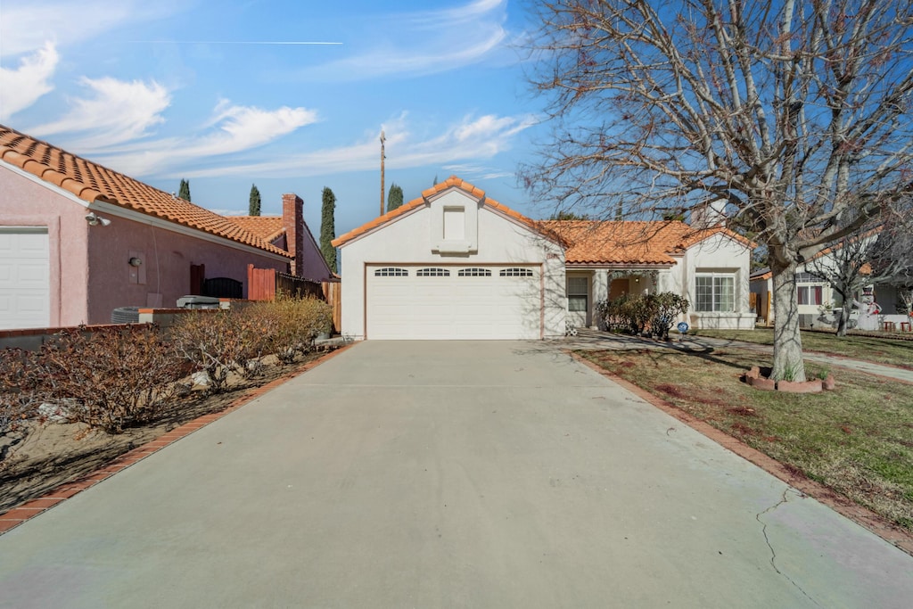 mediterranean / spanish home featuring a garage