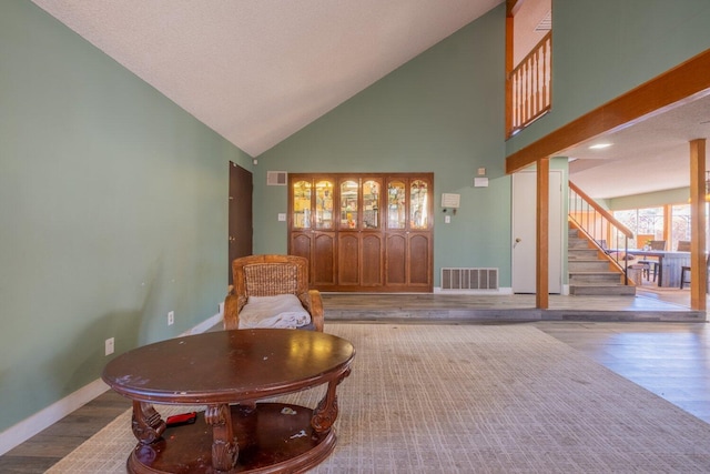 sitting room featuring hardwood / wood-style flooring and high vaulted ceiling