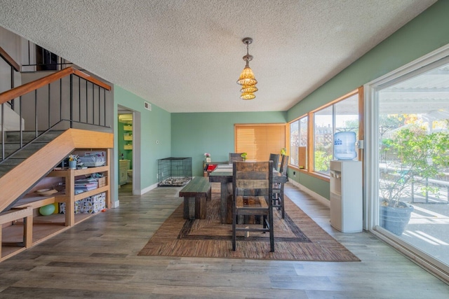 dining room with hardwood / wood-style flooring and a textured ceiling