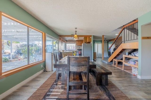 dining space with hardwood / wood-style floors and a textured ceiling