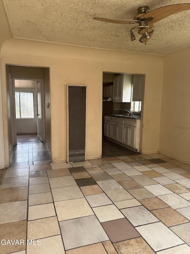 338 E 107th St, Los Angeles, CA 90003 - unfurnished living room with a heating unit, a ceiling fan, and a textured ceiling