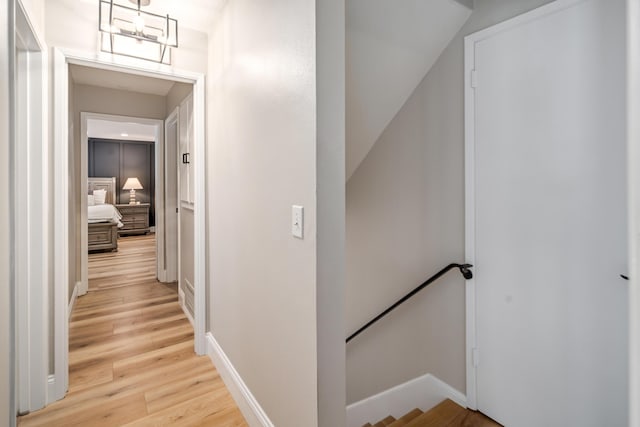 corridor with light hardwood / wood-style floors and vaulted ceiling