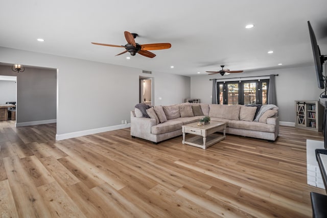 living room featuring ceiling fan and light wood-type flooring