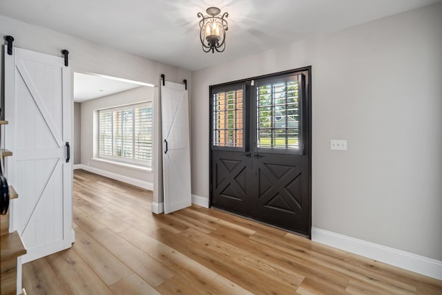 entryway featuring a barn door and light hardwood / wood-style flooring