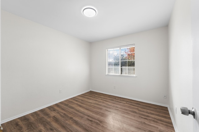 unfurnished room with dark hardwood / wood-style flooring