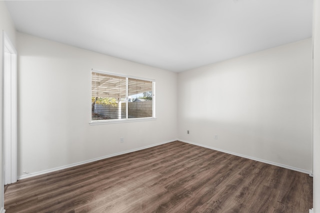 unfurnished room with dark hardwood / wood-style flooring