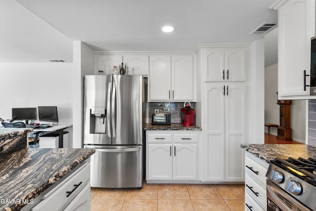 2512 Mildwood Ct, Lancaster, CA 93536 - kitchen with stainless steel appliances, white cabinets, dark stone counters, light tile patterned floors, and recessed lighting