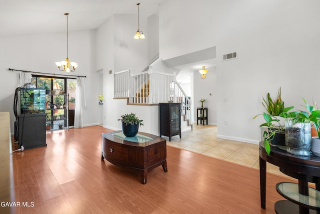 2512 Mildwood Ct, Lancaster, CA 93536 - living area featuring high vaulted ceiling, stairs, a chandelier, and light wood-type flooring