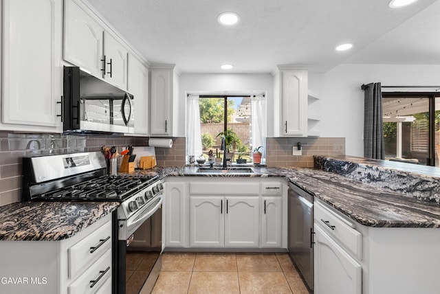 2512 Mildwood Ct, Lancaster, CA 93536 - kitchen featuring stainless steel appliances, a peninsula, dark stone counters, white cabinets, and recessed lighting