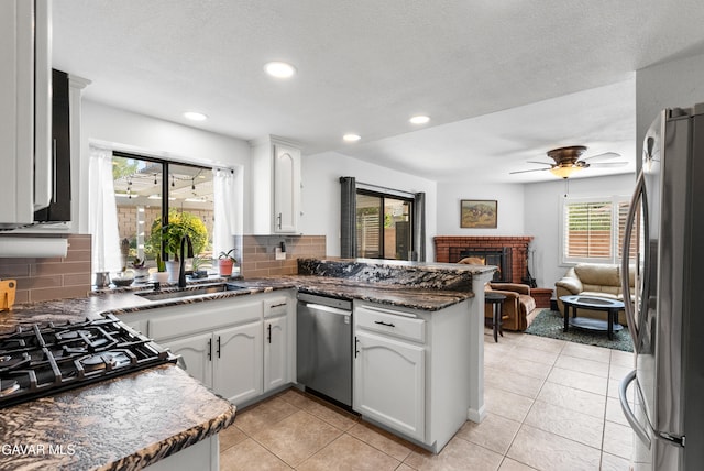 2512 Mildwood Ct, Lancaster, CA 93536 - kitchen featuring stainless steel appliances, a peninsula, backsplash, white cabinetry, and a ceiling fan